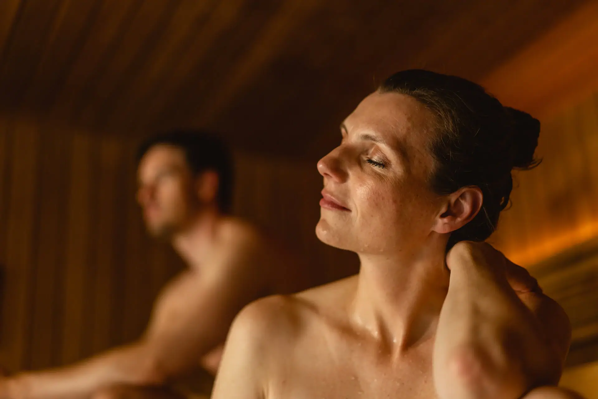 Sauna Travemünde Eine Frau mit geschlossenen Augen in einer Sauna.