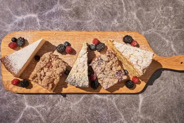 Verschiedene Desserts auf einem hölzernen Schneidebrett.