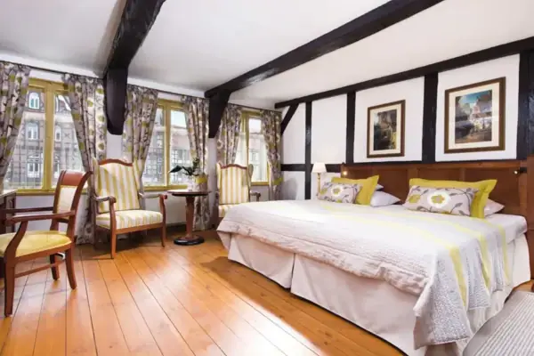 Ein Zimmer mit einem Bett und Stühlen.