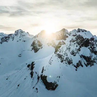 Verschneite Berggipfel mit Sonnenschein.