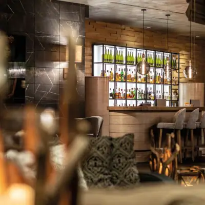 Ein Barbereich mit Flaschen Alkohol auf den Regalen.