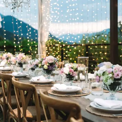 Ein festlich gedeckter Tisch mit Tischdecke, Geschirr, Gläsern und einem dekorativen Mittelstück.