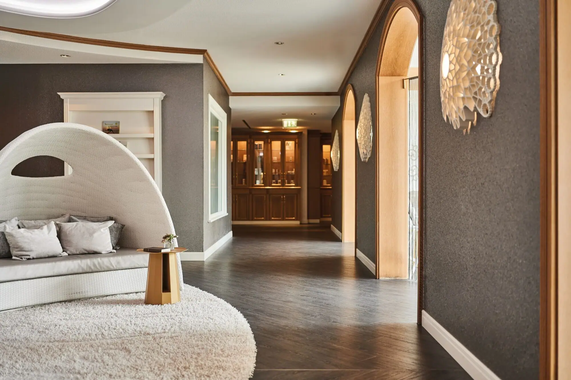 Spa Kurhaus Binz Der Eingang zum Spa Bereich im Kurhaus Binz mit weißem Teppich und rundem Stuhl.