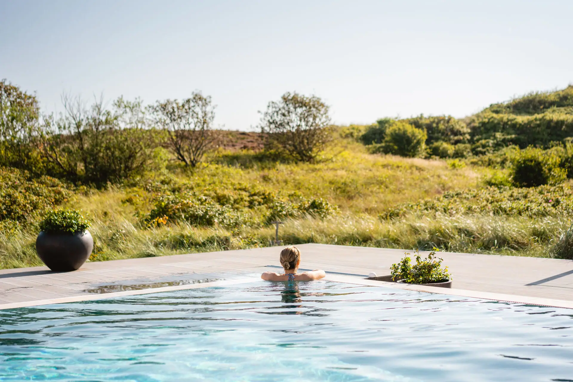 Außenpool A-ROSA Sylt Frau in einem Schwimmbecken im Freien