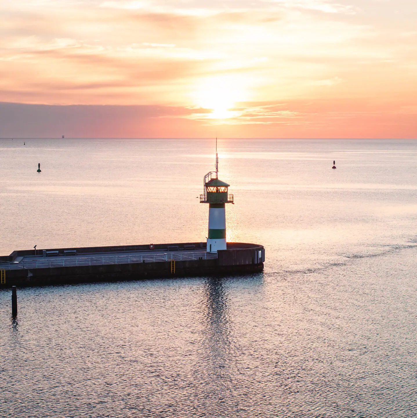 Ein Pier mit einem Leuchtturm im Wasser.