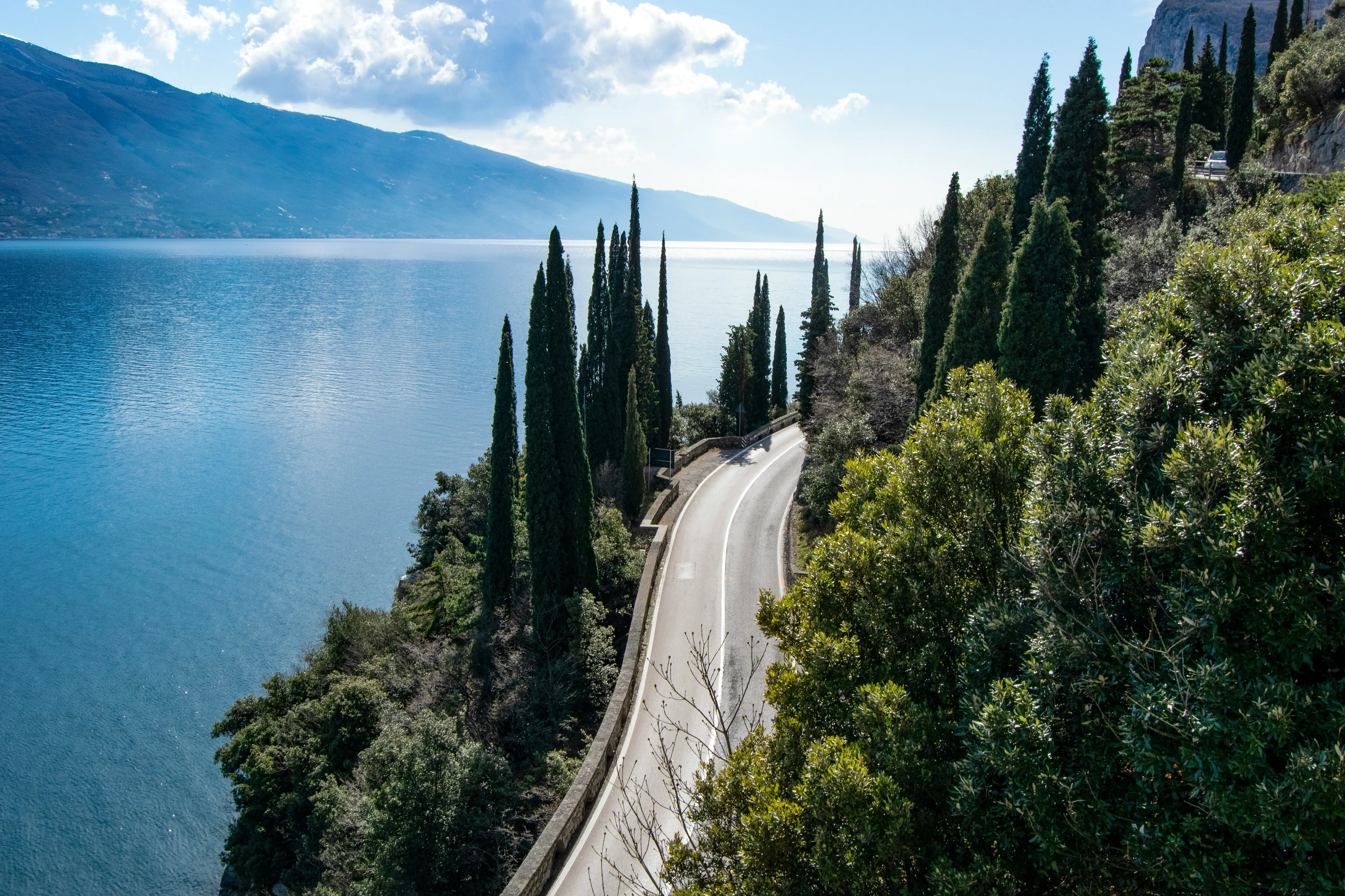 Gardasee Straße mit Bäumen entlang eines Gewässers