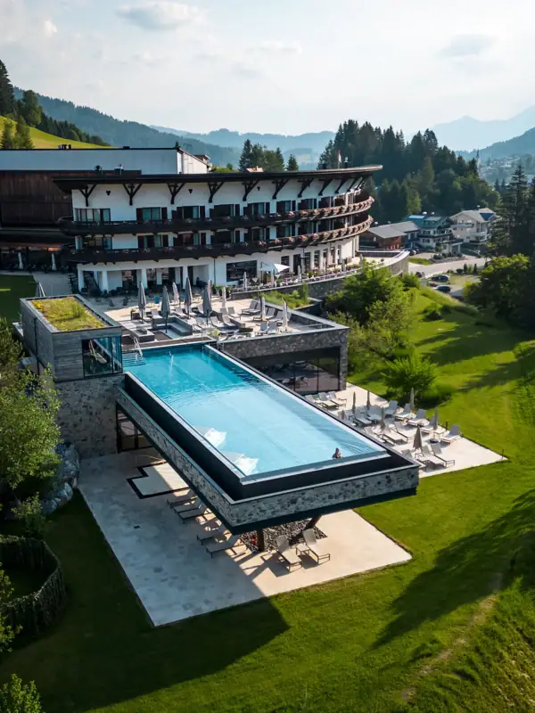 Hotelpool auf Stelzen im Freien mit Bäumen und Himmel im Hintergrund.