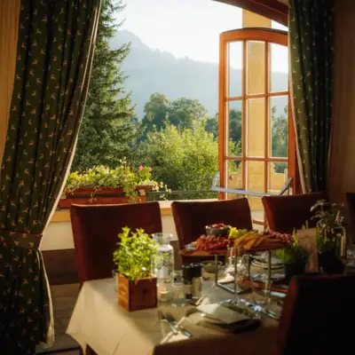 Schlossevents Ein Tisch mit Speisen darauf und ein Fenster mit Blick auf die Berge.