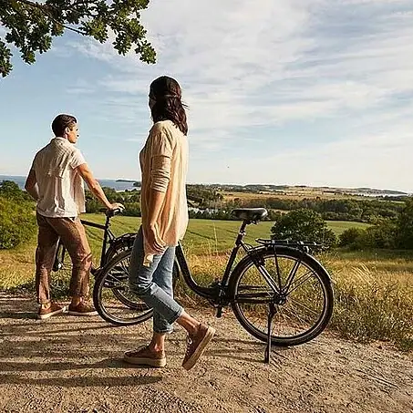 Ein Mann und eine Frau stehen neben Fahrrädern im Freien.