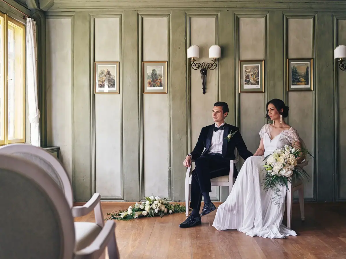Hochzeitspaar Ein Mann und eine Frau in Hochzeitskleidung sitzen auf Stühlen.