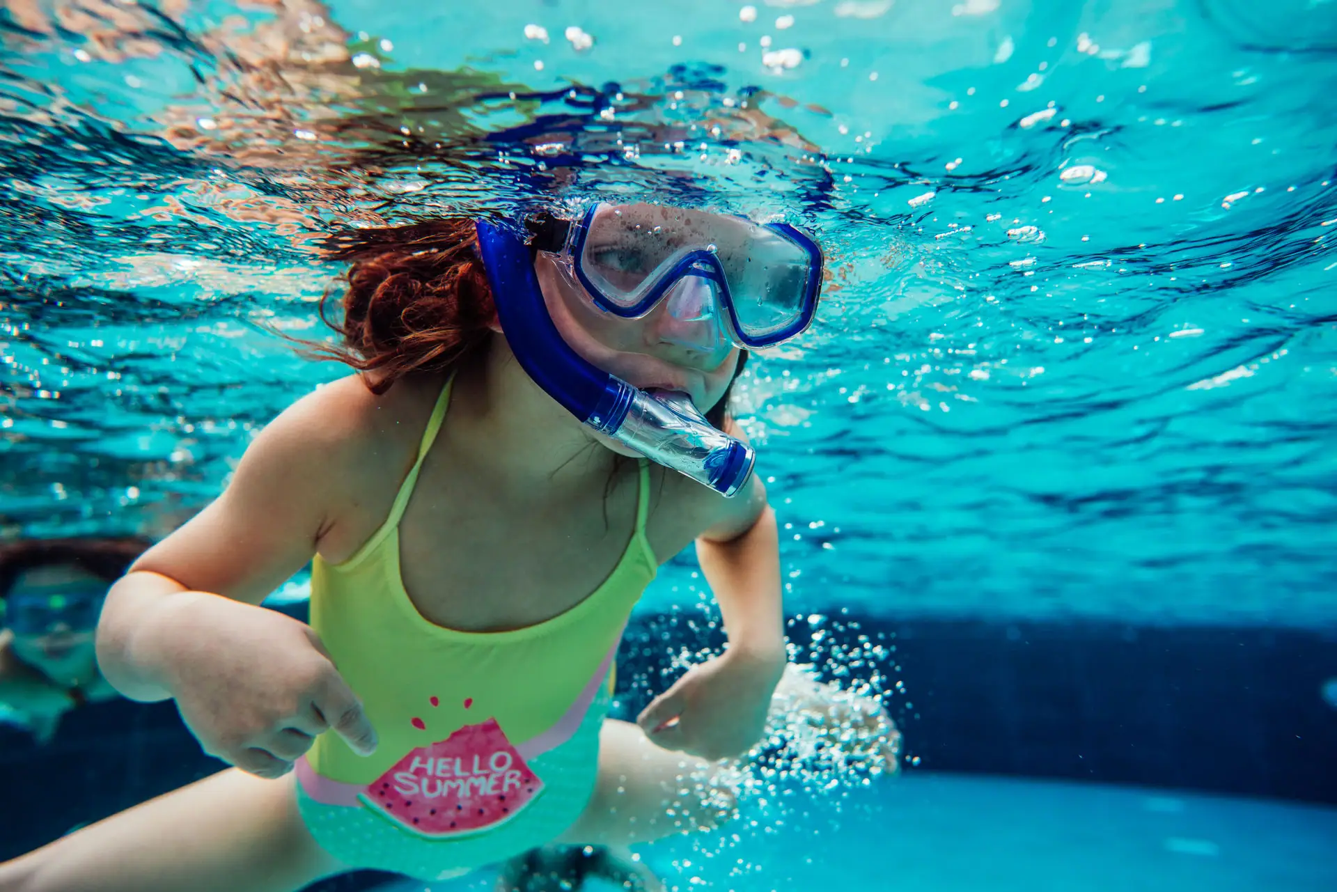 Schwimmkurs Travemünde Ein Mädchen mit Taucherbrille schnorchelt unter Wasser.