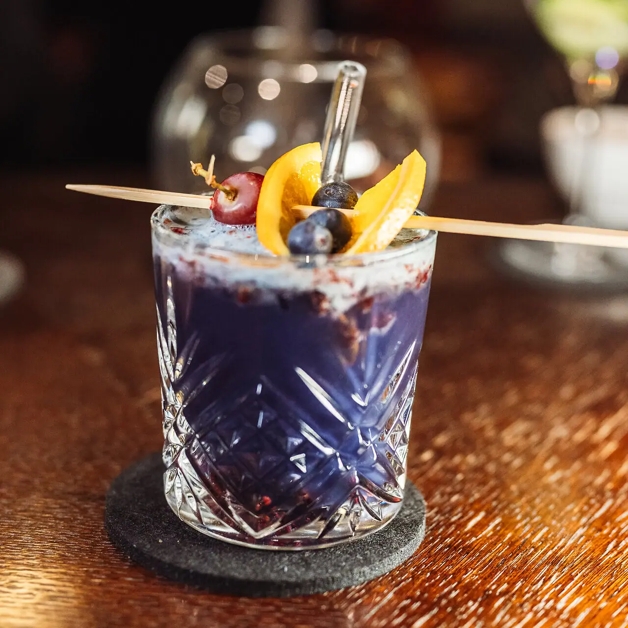 Cocktail Ein Glas mit einem Getränk und einer Fruchtgarnitur.