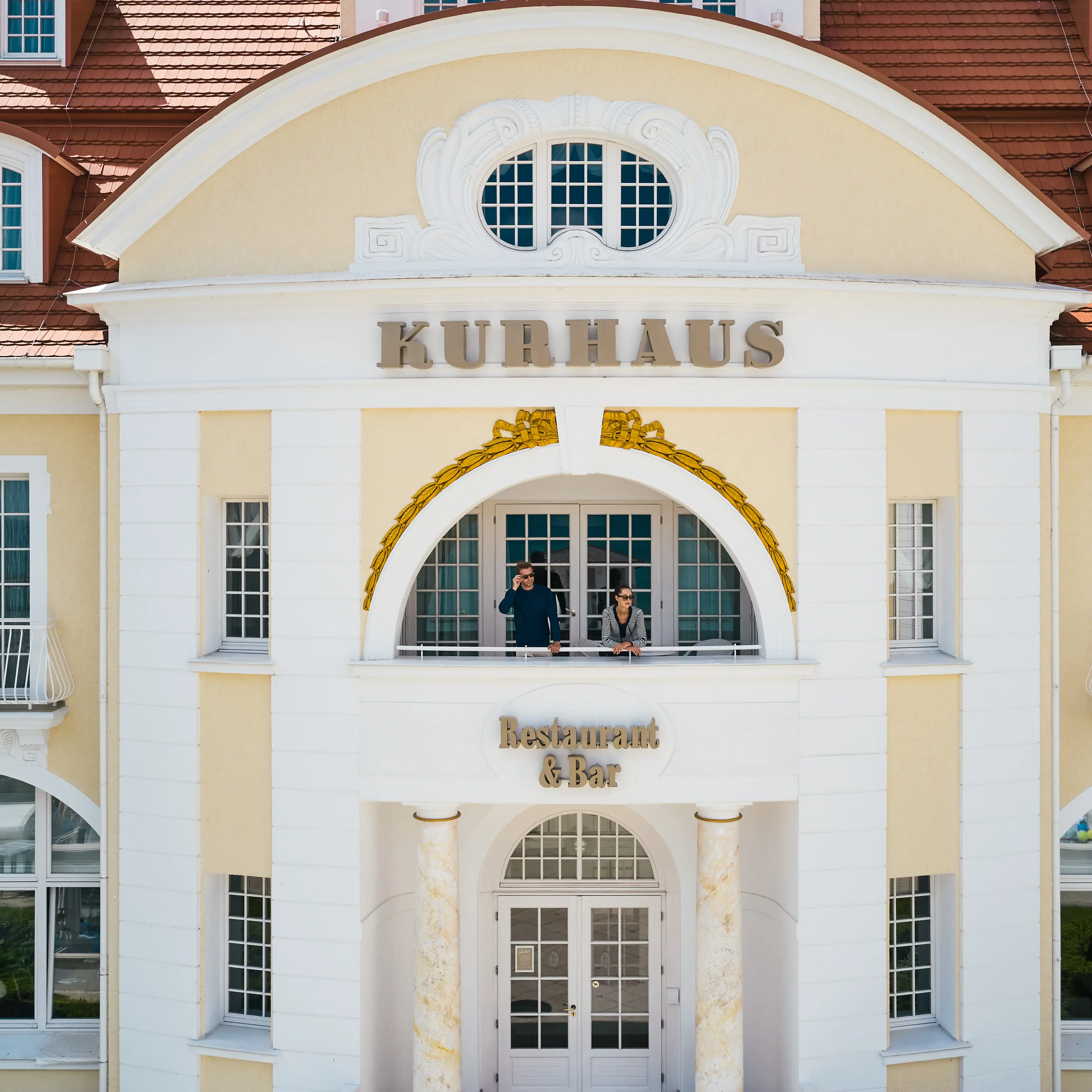 Ein Gebäude mit einem Paar, das auf dem Balkon steht.