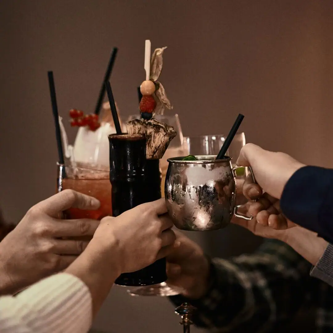 Eine Gruppe von Menschen hebt Getränke in die Höhe.