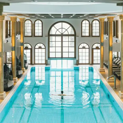 Pool mit Säulen und einer Person in der Mitte des Pools