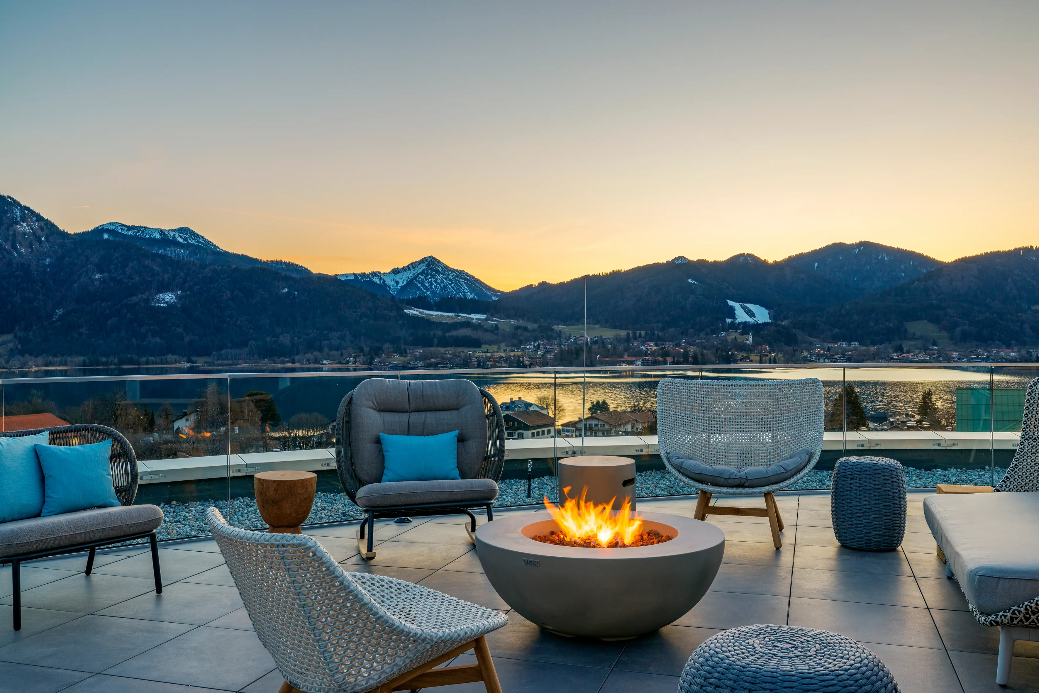 Rooftopbar Feuerstelle mit Stühlen und Blick auf Berge im Hintergrund