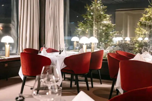 Thurnher’s Restaurant Ein Raum mit einem gedeckten Tisch und roten Stühlen..