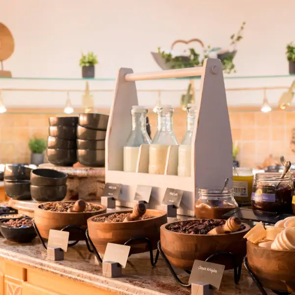 Frühstücksbuffet Ein Tresen mit Schüsseln voller Essen und Flaschen