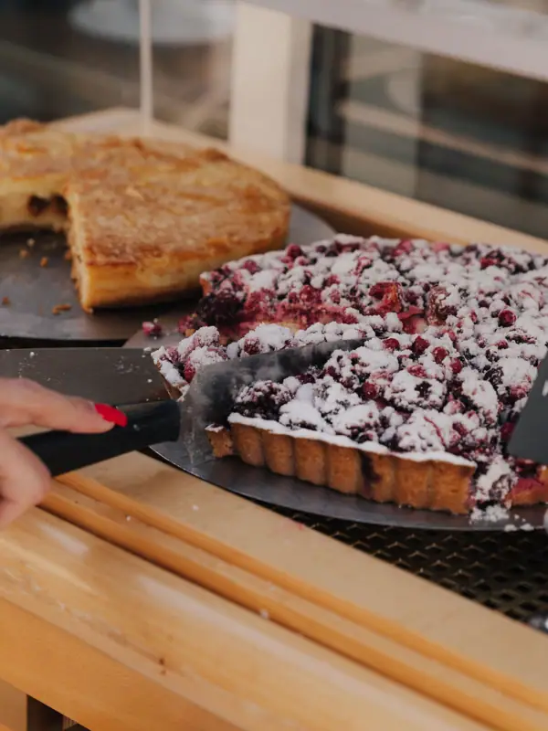 Eine Person schneidet einen Kuchen.