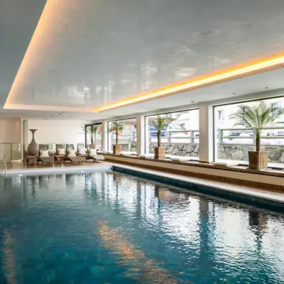 Wellness Ein großes Hallenbad mit einem großen Pool und einem großen Fenster.