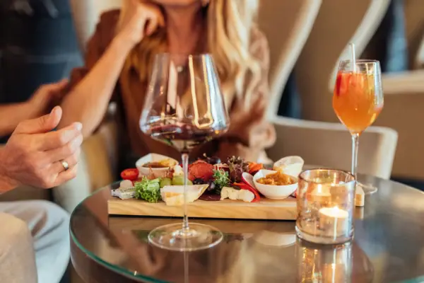 Paar während des Essens Ein Tisch mit Essen und Getränken, darunter Weingläser und Tischgeschirr.