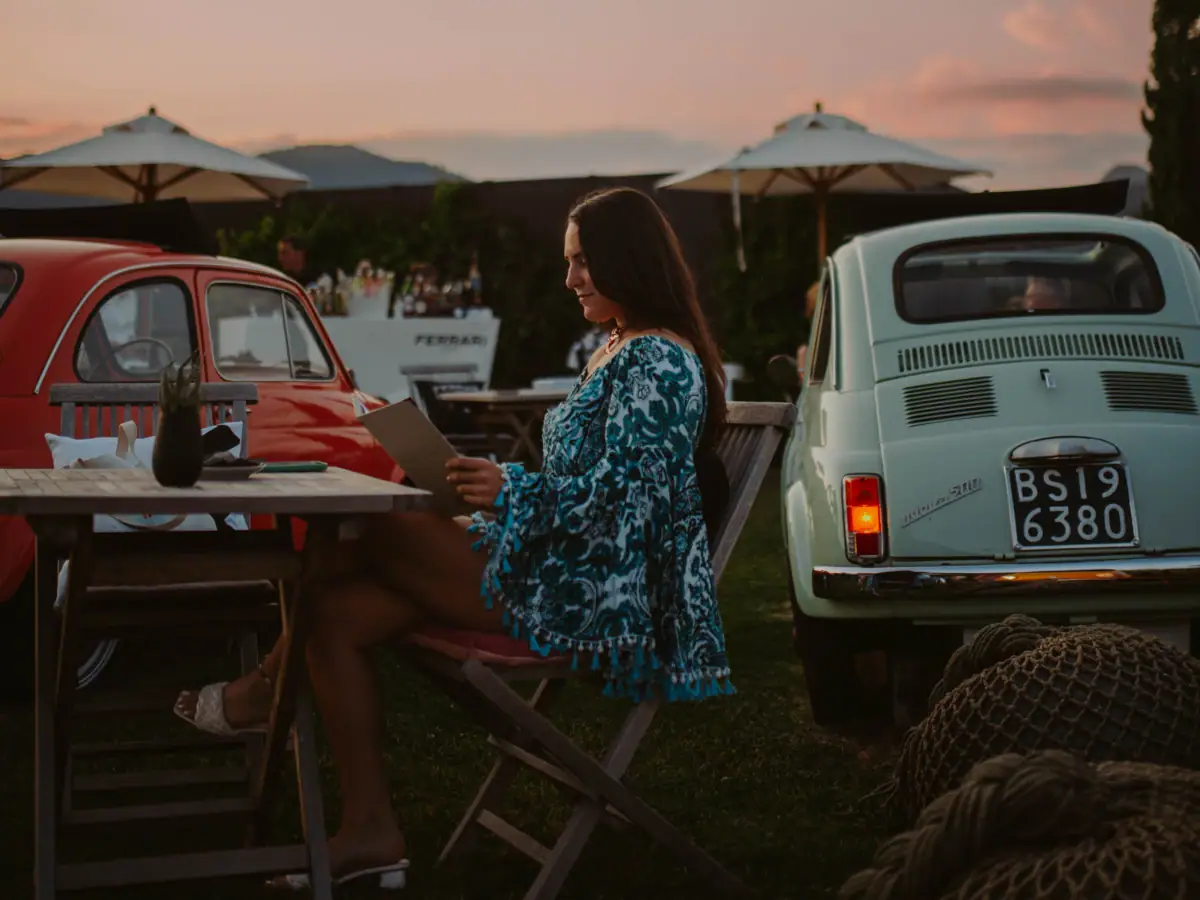 Fiat 500 Terrasse Eine Frau sitzt an einem Tisch mit einer Speisekarte.