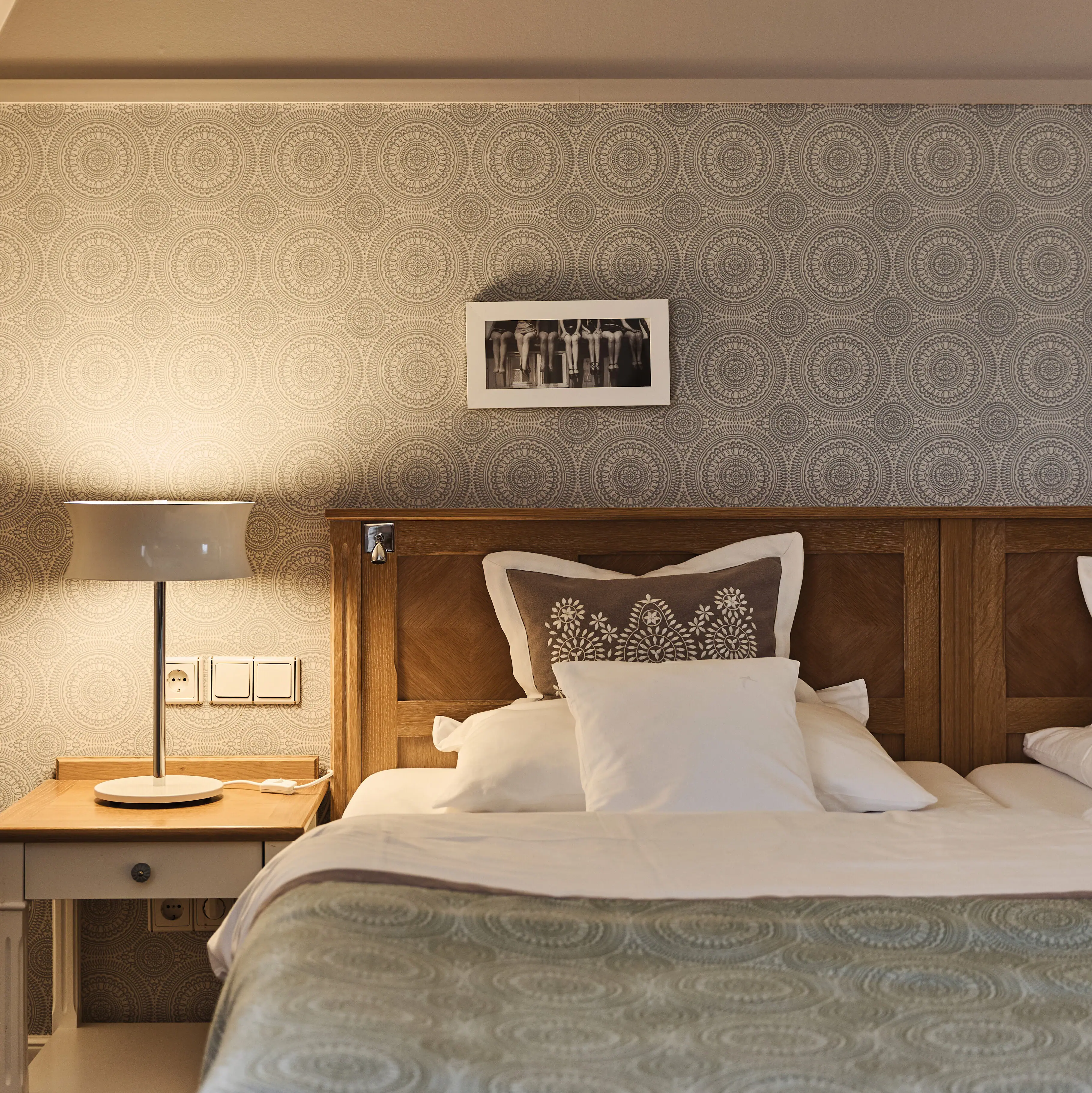 Ein Bett mit Nachtschrank und Bettwäsche