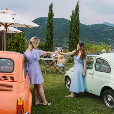 Zwei Frauen stehen neben einem Auto im Freien.