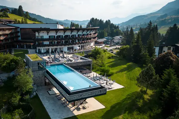 Ifen Hotel Kleinwalsertal Ein Swimmingpool im Freien mit Blick auf Bäume und Himmel.