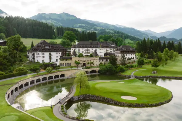 Schlosshotel Kitzbühel Golfplatz mit dem Schlosshotel Kitzbühel und Bergen im Hintergrund.