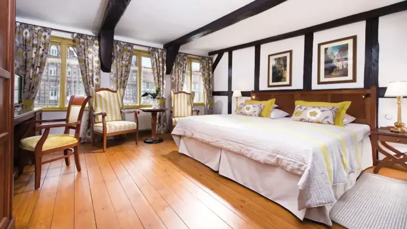 Ein Zimmer mit einem Bett und Stühlen.