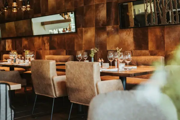 Ein Tisch mit Weingläsern und Stühlen in einem Restaurant.