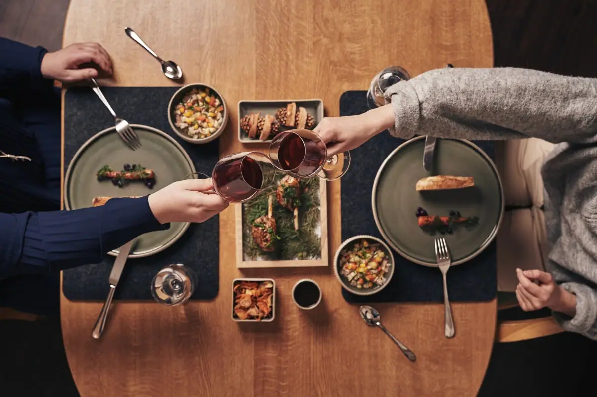 Paar prostet sich zu von oben am Dinnertisch