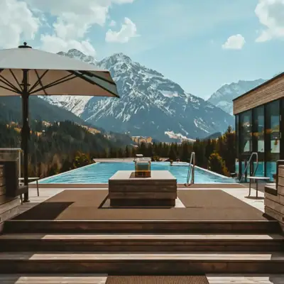 Wellness im Ifen Hotel Kleinwalsertal Ein Outdoor Infinity Pool mit Holzdeck und großem Sonnenschirm vor einer schneebedeckten Bergkulisse im Hintergrund.