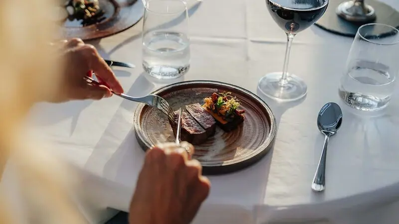 Belvedere Restaurant Gericht Person isst von einem Teller im Belvedere Restaurant Heringsdorf.