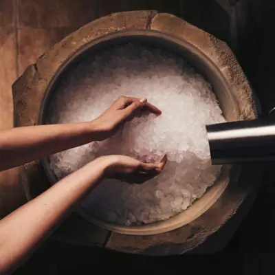 Hände einer Person über einer Schüssel mit Eis