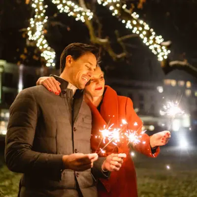 Silvester-Arrangements Ein Mann und eine Frau halten Wunderkerzen.