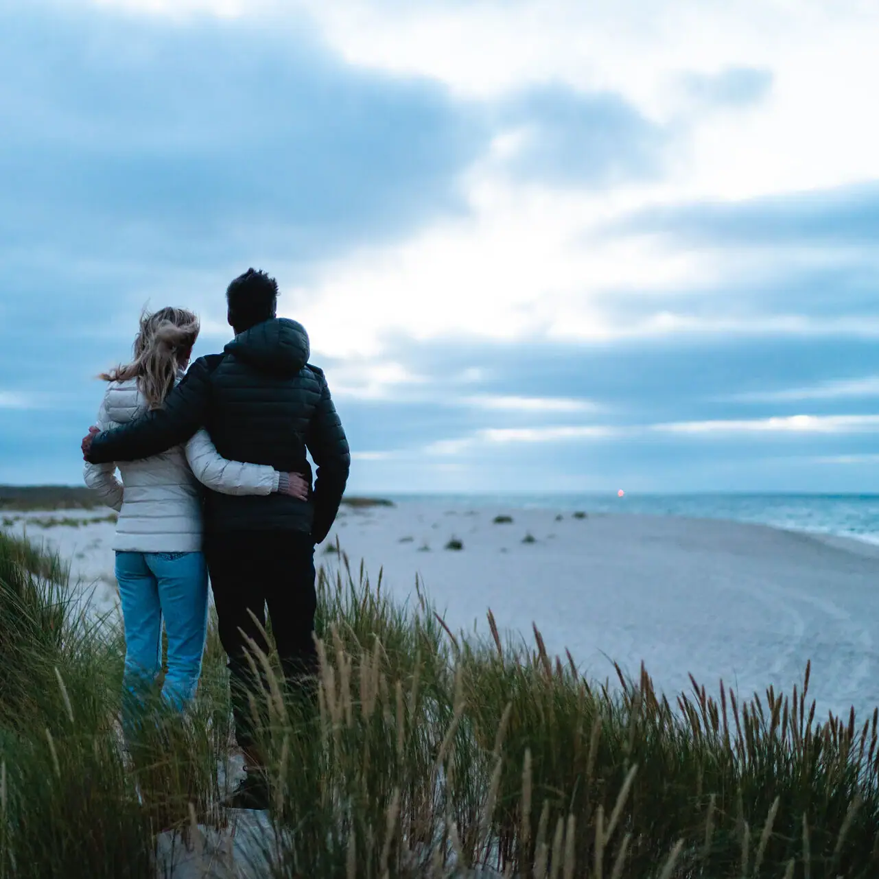 Ein Mann und eine Frau stehen am Strand.