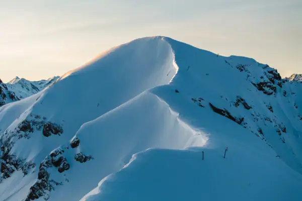 Schneebedeckter Berggipfel unter klarem Himmel.