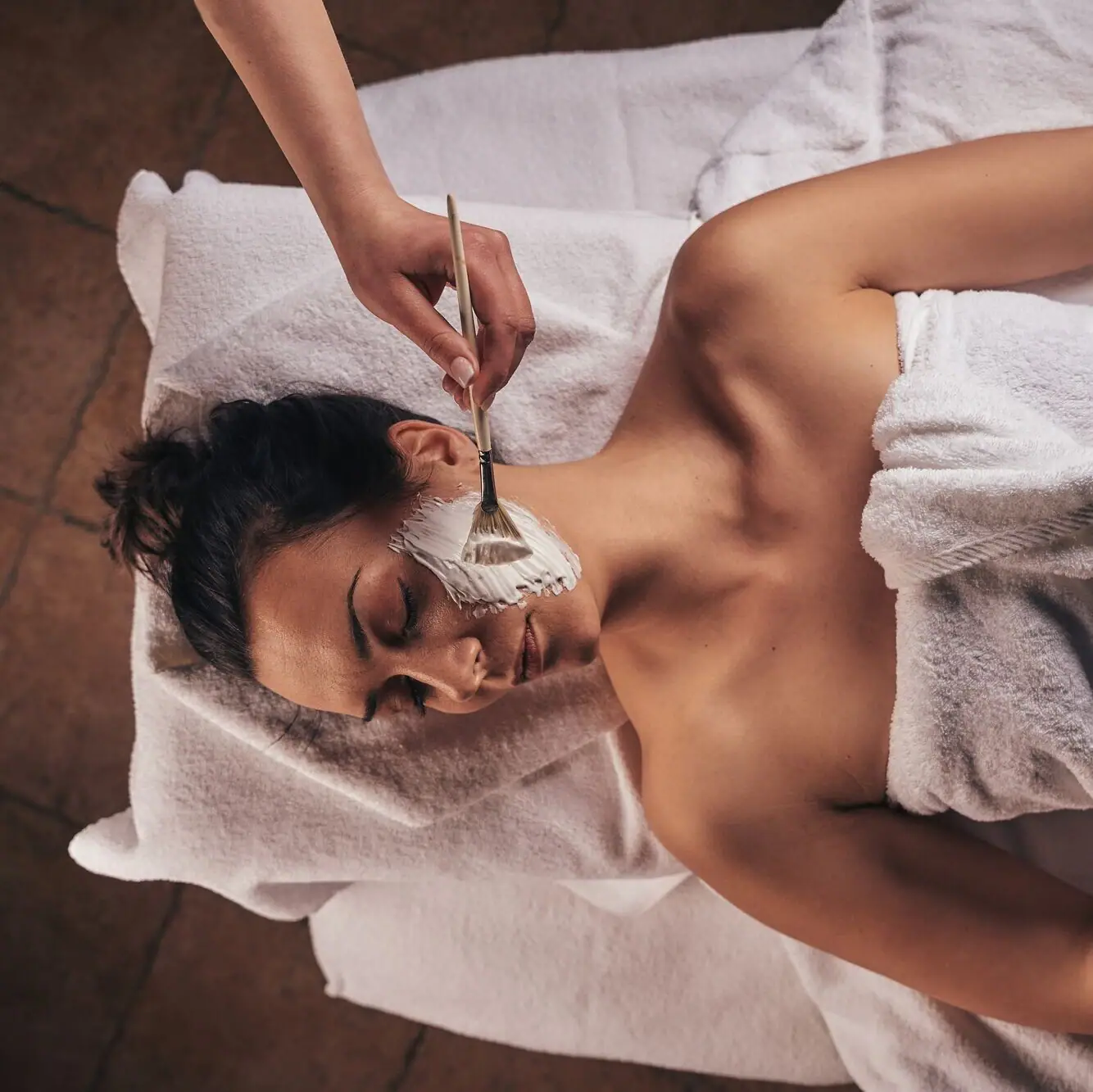 Eine Frau liegt mit einer Gesichtsmaske im Gesicht.