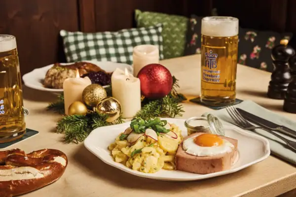 Ein Teller mit Essen und ein Bier auf einem Tisch.