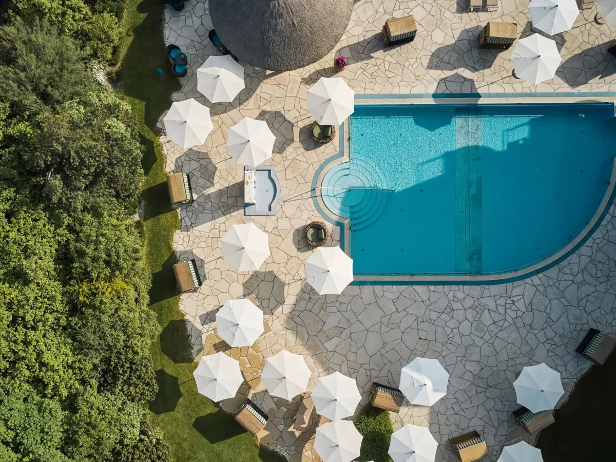 Poollandschaft aus der Vogelperspektive im A-ROSA Ostseehotel Kühlungsborn Außenpool mit Sonnenschirmen und Liegen im A-ROSA Ostseehotel Kühlungsborn