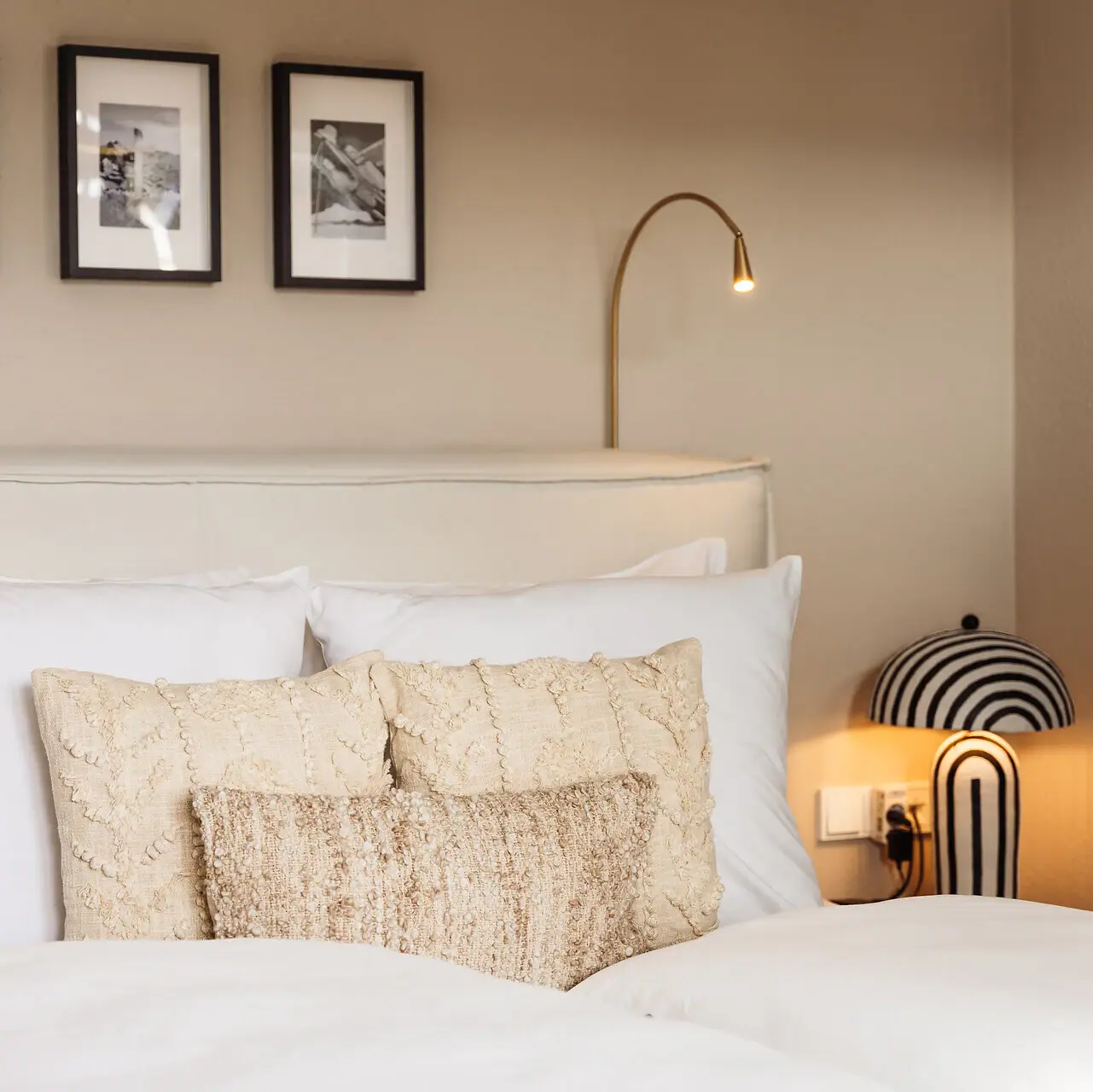 Ein Bett mit Kissen und einer Lampe.