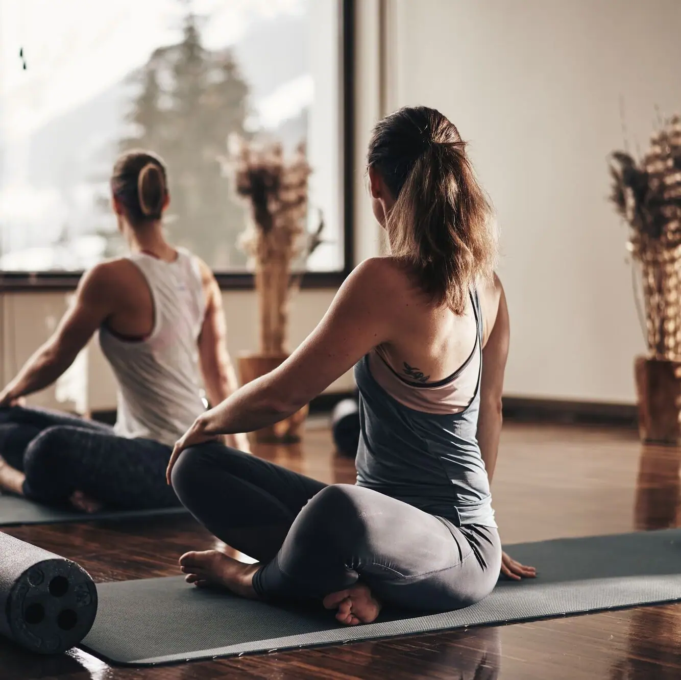 Yoga im Ifen Hotel Kleinwalsertal Eine Gruppe von Frauen sitzt auf Yogamatten.
