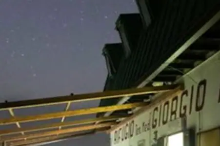 Nachtwanderung Gardasee Ein Gebäude mit einer Bank und einem Tisch im Freien bei Nacht.