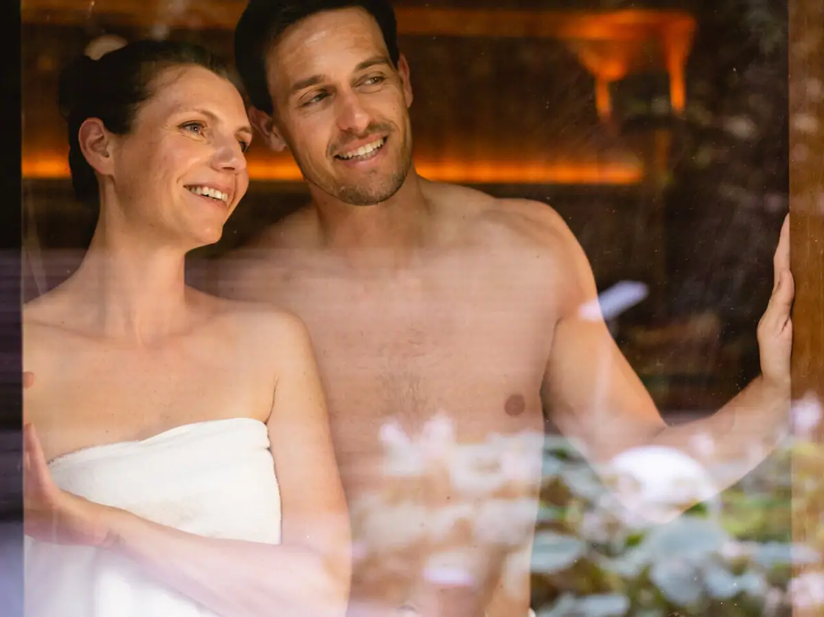 Paar in der Sauna Ein Mann und eine Frau in Handtücher gehüllt.