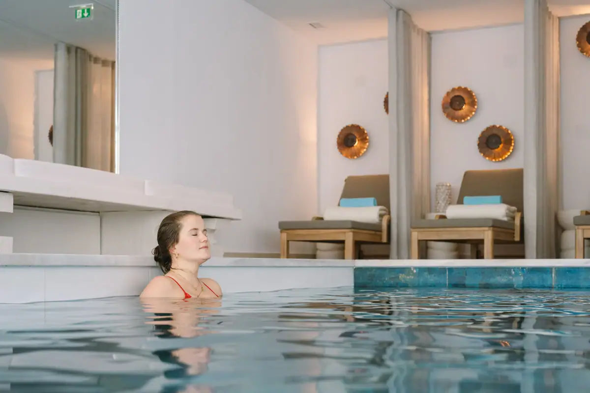 Frau entspannt im Pool Eine Frau schwimmt in einem Pool.