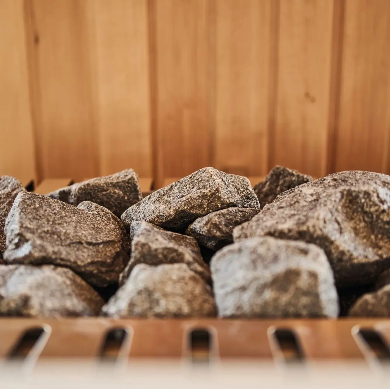 Sauna im Ifen Hotel Kleinwalsertal Ein Haufen Steine auf einem Ofen in einer Sauna.