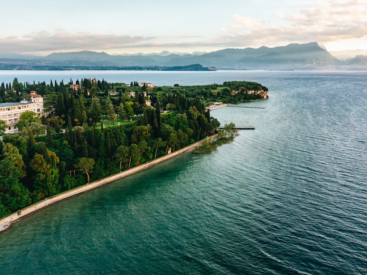 Panoramablick über den Gardasee Weitläufige Aussicht über den Gardasee mit üppigen Zypressen und malerischer Küstenlinie