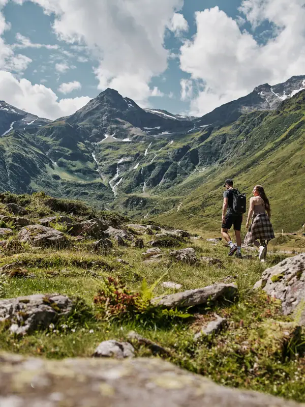 Ein Paar spaziert auf einem Bergpfad.